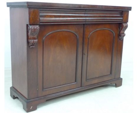 A Victorian mahogany chiffonier, two frieze drawers, carved corbels flanking two doors, single shelf within, with key, 122 by