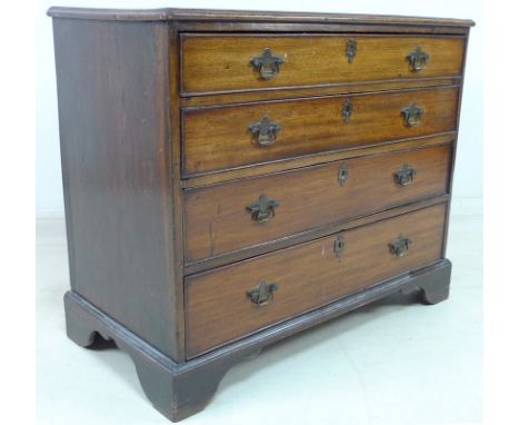 A George III mahogany chest of four graduating drawers with cock beading, brass swan neck handles and escutcheons, raised on 