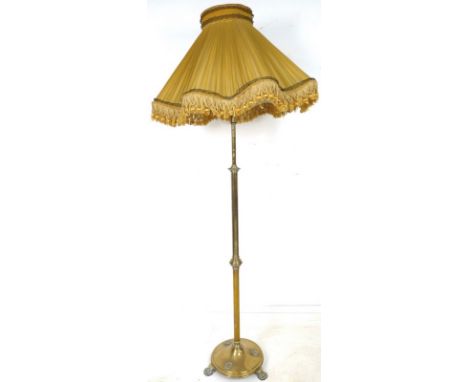 A Victorian brass standard lamp, the knopped plain column on a circular base with three applied decorative wreaths, raised on
