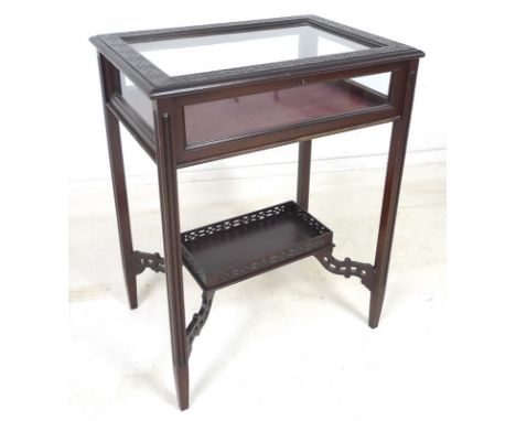 An Edwardian mahogany vitrine with blind carved decoration, lower tier shelf with pierced gallery, with key, 59 by 42 by 75.5