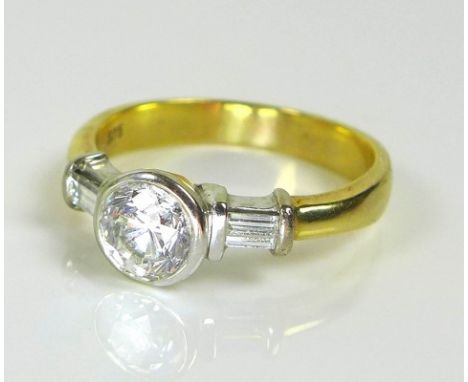 A modernist style diamond dress ring, the single brilliant cut diamond of approximately 1ct, with baguette cut diamonds to ei