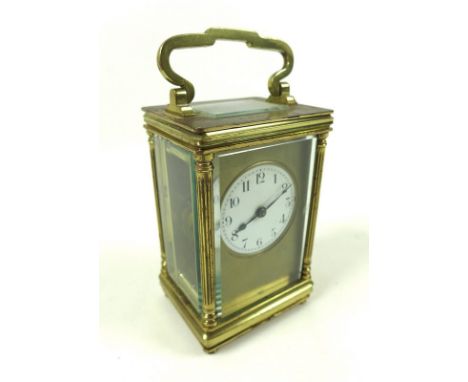 A 20th century carriage clock, brass case with reeded columns flanking the front, the white enamel dial with Arabic numerals,