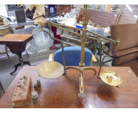 A set of brass scales and a quantity of brass weights.