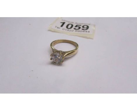 A 9ct gold ring set with a white stone, size L half.