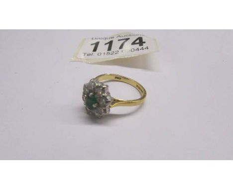 An 18ct gold ring set 8 diamonds and an emerald, size P, 5 grams.