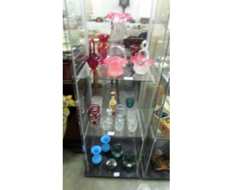 Three shelves of assorted coloured glass ware including baskets, vases etc., Condition report;Pink basket on top shelf has mi
