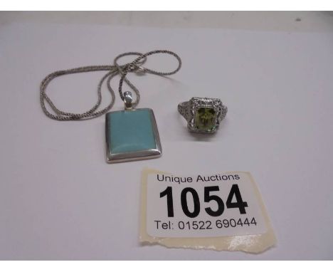 A silver pendant on chain and a silver ring.