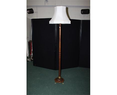 Mahogany standard lamp, with turned stem, on a circular plinth base raised on brass paw feet, 197cm high