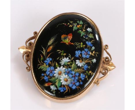 Yellow metal and enamel brooch, with a central panel decorated with flowers and a butterfly, 35mm diameter 
