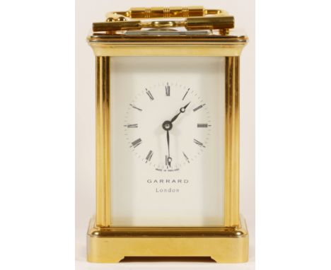 An English brass 8 day carriage clock, retailed by Garrard Of London, with key and presentation box. 12cm tall. 