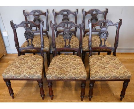 A set of six Victorian rosewood dining chairs, having ornate carved shaped back with carved centre splat, upholstered tapestr