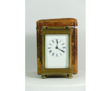 An early 20th century brass carriage clock, having an 8 day movement, with traveling case and key. 12.5cm tall. 