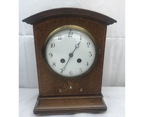 An inlaid oak mantel clock