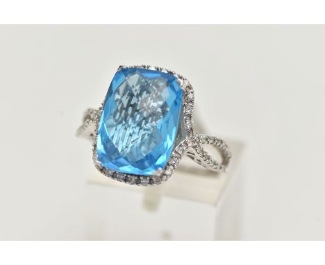 A 'KALLATI' TOPAZ AND DIAMOND DRESS RING, a large rectangular cut blue topaz, approximate length 14mm x width 10mm, set with 