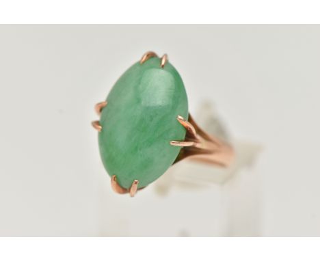 A CHINESE JADE CABOCHON RING, designed as an oval jade cabochon within an eight claw setting to the trifurcated shoulders, st