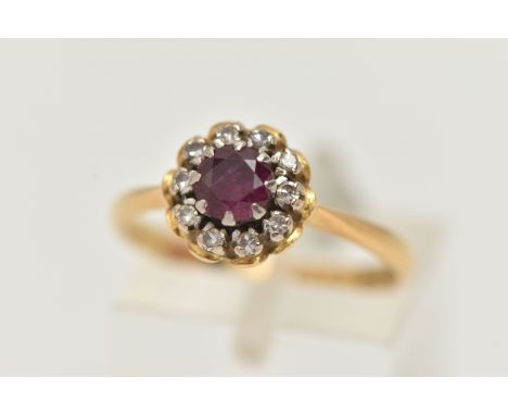 AN 18CT GOLD RUBY AND DIAMOND CLUSTER RING, of a circular form, centrally set with a circular cut ruby, in an eight claw sett