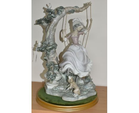 A LLADRO 'SWINGING' SCULPTURE OF A GIRL ON A SWING, model no 1297, sculptor Salvador Debon, issued 1974 - 1989, on a plinth s