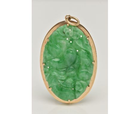 A 9CT GOLD CARVED JADE PENDANT, the oval jade panel carved to depict flowers, foliage and possibly fish, claw set in an oval 