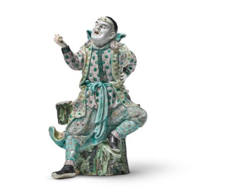 A CHINESE FAMILLE NOIRE FIGURE OF A GUARDIAN DEITY REPUBLICAN PERIOD  well modelled seated on a tree trunk 25cm     Condition