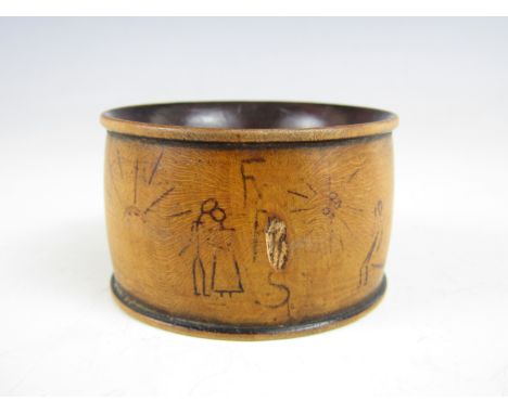 A Great War trench art wooden napkin ring, pen-worked in a chronological series of 'stick man' vignettes describing a soldier