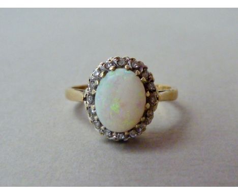 An opal and diamond dress ring, with claw set cabochon of approximately 1.10ct, claw set within an illusion set frame of diam