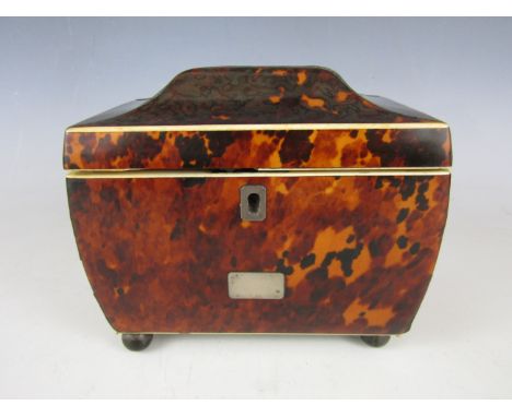 A Regency tortoiseshell tea caddy, of sarcophagus form with ivory and silver string inlay, opening to reveal a fitted interio