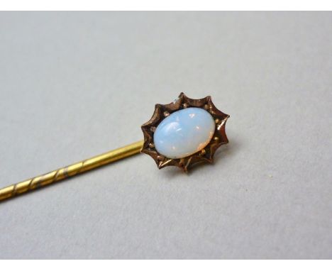 A yellow-metal and opal stick pin, the cabochon pellet-set within a cusped frame