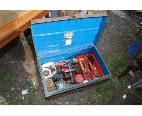 A metal trunk with contents, hand tools and foot pump.