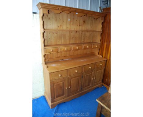 A modern pine dresser with five small drawers and two cupboards, 58 1/2" wide x 17" deep x 74" high.