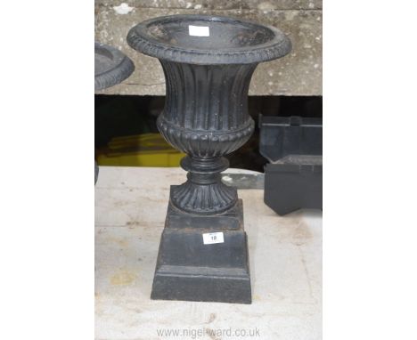 An elegant cast iron planter/urn having fluted and reeded design and an associated matching but separate plinth base, 20" hig