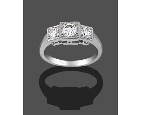 A Diamond Three Stone Ring, the graduated round brilliant cut diamonds in white claw and millegrain settings, on a tapered sh