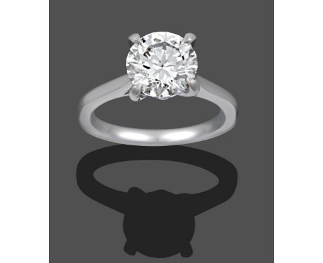 A Platinum Diamond Solitaire Ring, the round brilliant cut diamond in a white four claw setting, on a tapered shoulder plain 