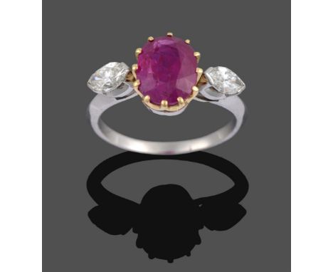 A Ruby and Diamond Three Stone Ring, the oval cut ruby in a yellow claw setting sits between two marquise cut diamonds in whi