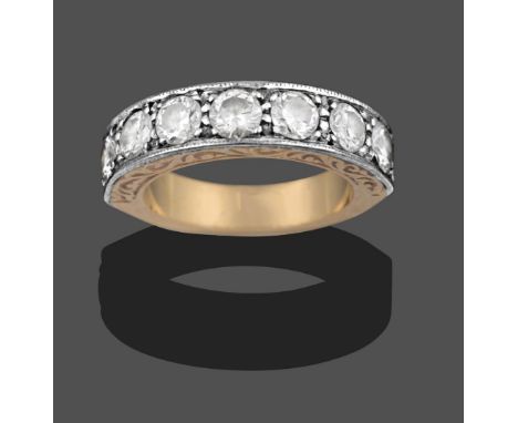 An 18 Carat Gold Diamond Seven Stone Ring, the round brilliant cut diamonds in white claw and channel settings, to a yellow p