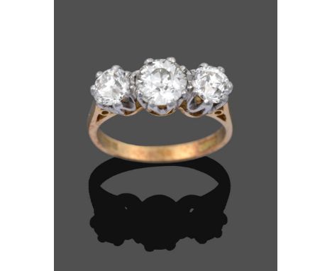An 18 Carat Gold Diamond Three Stone Ring, the graduated old cut diamonds in white claw settings, on a yellow tapered shoulde