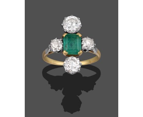 An Emerald and Diamond Ring, the emerald-cut emerald in yellow claws, flanked by an old cut diamond on each shoulder and a ro