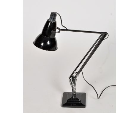 A black metal table-top anglepoise lamp on stepped square base.