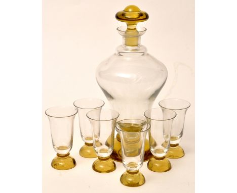 A hand blown glass liquor decanter, with yellow stopper and base; together with six matching liquor glasses, 23cms (9in.) hei