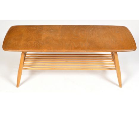 Ercol: a light elm and beech wood occasional coffee table, shaped rectangular, with magazine rack below, 104 x 46 x 37cms hig