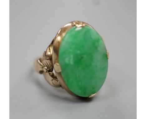 A yellow metal and oval cabochon jade set ring, size K/L, gross weight 3.5 grams.