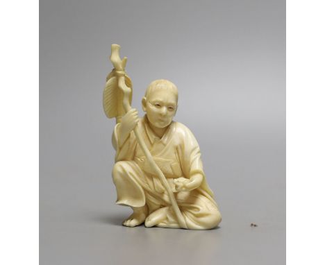 A Japanese ivory okimono of seated figure, early 20th century (possibly  Gama Sennin) with paddle and holding a frog - 10cm t