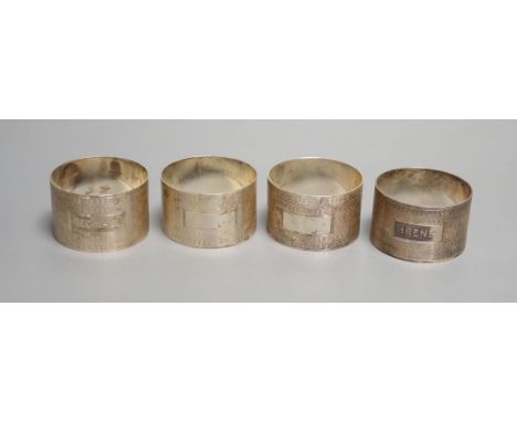 A set of four George VI engine turned silver napkin rings, H. Bros, Birmingham, 1943/4, two engraved with names.