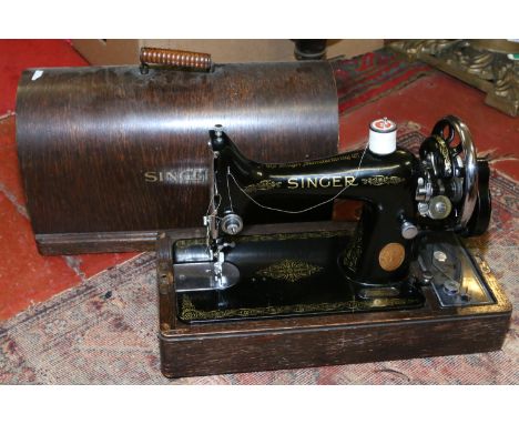 A cased Singer manual sewing machine.