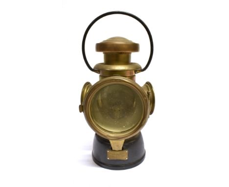 A LUCAS KING OF THE ROAD NO. 432 MOTOR VEHICLE REAR LAMP  the brass body with black painted base and stirrup mounting bracket