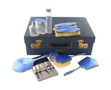 An Art Deco George V silver and blue enamel 10-piece travelling vanity set, in blue leather-covered case, including hand mirr