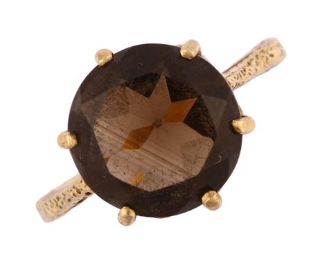 A late 20th century 9ct gold smoky quartz dress ring, set with round-cut quartz with textured shoulders, hallmarks London 197