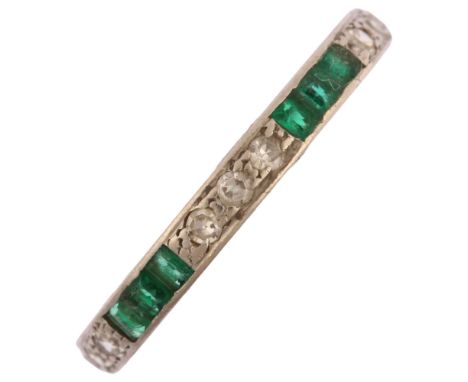 An emerald and diamond full eternity ring, unmarked white metal settings with trio of single-cut diamonds and calibre-cut eme