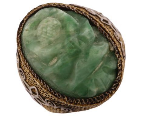 An Arts and Crafts Chinese silver-gilt jade ring, relief carved panel depicting blossom with filigree applied flowerhead shou