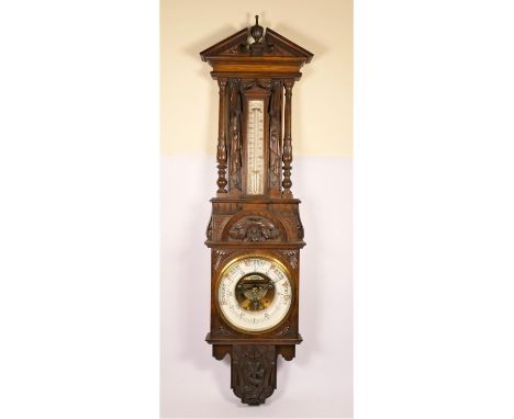 An Edwardian carved oak wall aneroid barometer with thermometer, ornately carved case with Neptune's Trident and a sea serpen