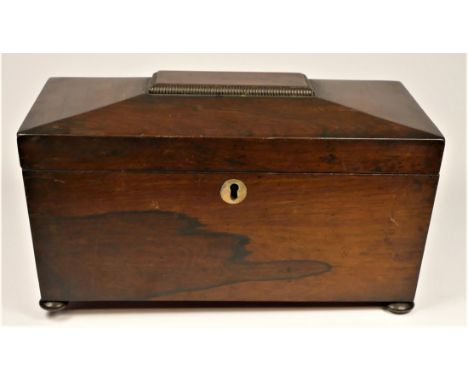 A regency rosewood tea caddy, the sarcophagus hinged lid opening to reveal a replacement glass mixing bowl flanked by lidded 